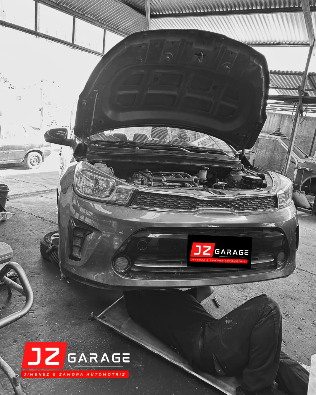 Vehículo con capó abierto durante un trabajo mecánico en JZ Garage