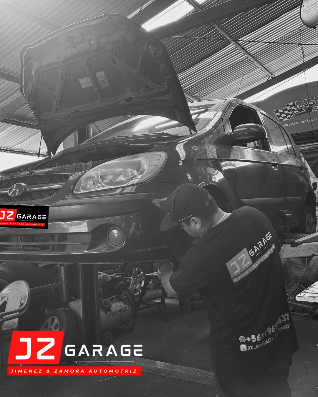 Mecánico trabajando junto a un vehículo elevado en JZ Garage