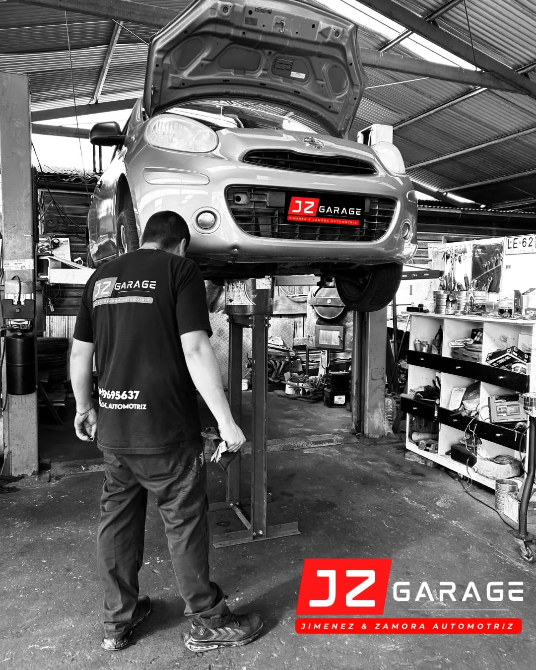 Mecánico de JZ Garage trabajando bajo un vehículo elevado